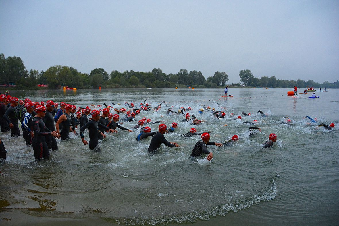 In der ersten Startwelle schieben sich die Altersklassenathleten ruhig hinter den Profis ins Wasser